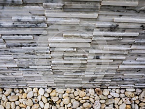 Small stones and grey marble stone texture brick wall