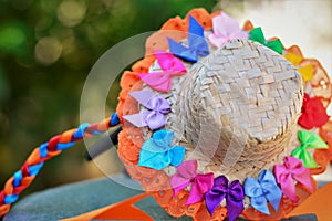 A small straw hat filled with small colored ribbons and lace and ribbon braid