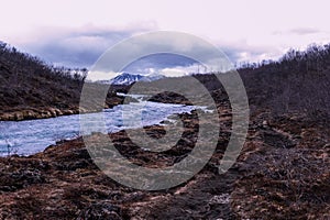 a small stream flows along a mountainous area surrounded by mountains