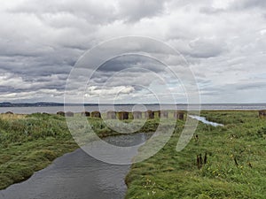 A small stream, and a line of old Tank Barriers at Tay Heath on the Tay estuary.