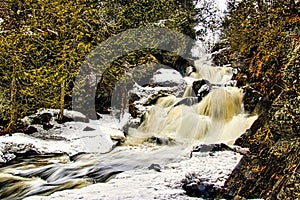 A small stream tumbles over a waterfall on a Winter day
