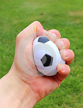 Small stress ball in hand on grass background