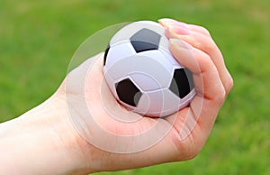 Small stress ball in hand on grass background