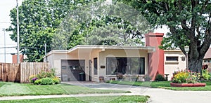 Small Stucco House with Flat Roof and Flower Beds