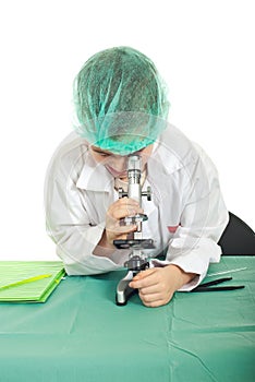 Small student looking into microscope