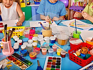 Small students girl and boy painting in art school class.