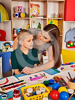 Small students girl and boy painting in art school class.