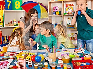 Small students girl finger painting in art school class.