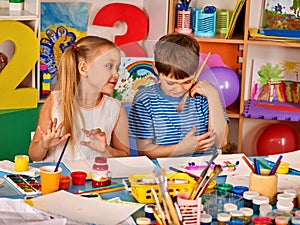 Small students girl painting in art school class.