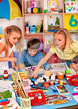 Small students girl painting in art school class.