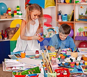 Small students girl painting in art school class.