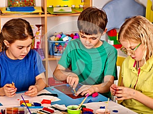 Small students girl painting in art school class.