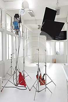 A small studio light and black cutters in white room