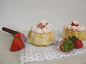 Small stuffed strawberry cakes with whipped cream