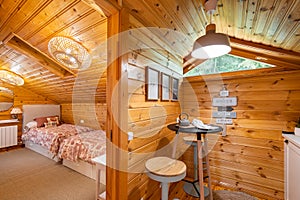 Small stylish kitchen and cozy bedroom in wooden house. Village life concept.