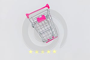 Small supermarket grocery push cart for shopping toy with wheels and 5 stars rating isolated on white background. Retail consumer