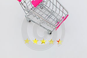 Small supermarket grocery push cart for shopping toy with wheels and 5 stars rating isolated on white background. Retail consumer