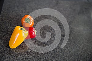 Small sweet peppers on black background in kitchen