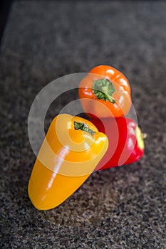 Small sweet peppers on black background in kitchen