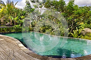 Small swimming pool with clear turquoise water among tropical plants