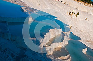The small swimming pools full of water in the white rocks made of calcium carbonate