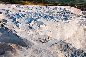 The small swimming pools full of water in the white rocks made of calcium carbonate