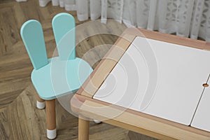 Small table and chair with bunny ears in children`s room