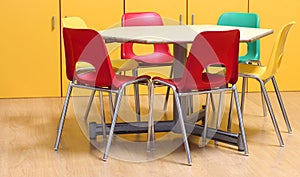 small table with colored chairs in the kindergarten classroom