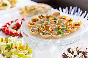 A small table with a delicious buffet of canapes, caviar, sandwiches