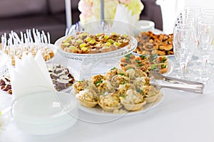 A small table with a delicious buffet of canapes, caviar, sandwiches