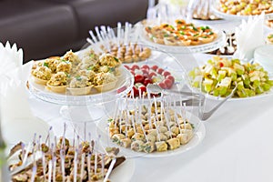 A small table with a delicious buffet of canapes, caviar, sandwiches