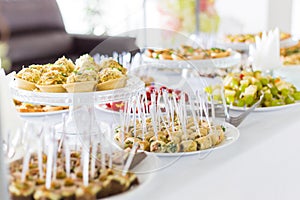 A small table with a delicious buffet of canapes, caviar, sandwiches