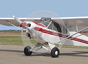 Small tail-wheel red and white airplane.