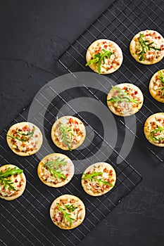 Small tarte flambee or mini pizza with onion, bacon and arugula