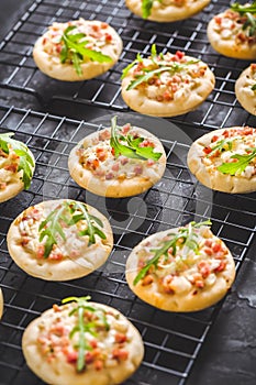 Small tarte flambee or mini pizza with onion, bacon and arugula