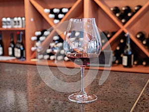 Small tasting glass of red wine on bar counter