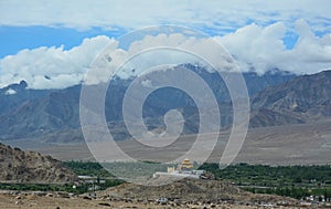 Small temple on top of hill with mountains in Ladakh, India