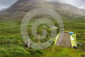 Small tent set up in a field, Smoke coming out from chimney, Mountain in fog in the background, Low clouds, Connemara, Ireland, Tr