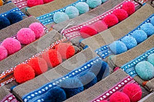 Small textile purses with colourful pompoms on display at street market in Morocco