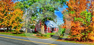 Small 18th century home surrounded by the beautiful colorful of VT fall foliage HDR.