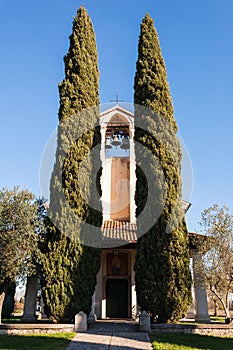 Small 13th century rural church with cypresses.