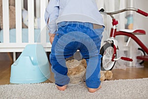 A small toddler boy, peeing in his pants, could not make it on time on the potty