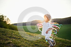 Small toddler girl playing on meadow outdoors in summer. Copy space.