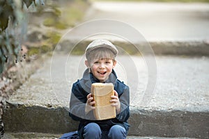 Small toddler is holding a large loaf of bread.