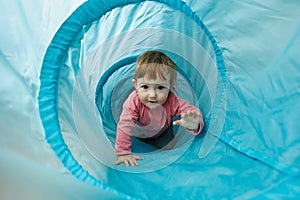 Small toddler playing in a tunnel tube
