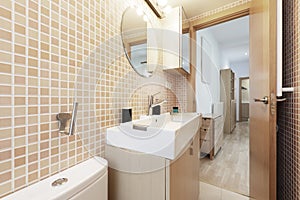 Small toilet with white porcelain sink, square shower with pink tiles