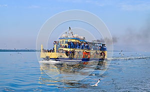 Small tourist ship with the passengers. Beautiful seascape with a tourist boat. The ferry just left the pier.