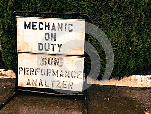 Small town mechanic on duty sign on a sidewalk