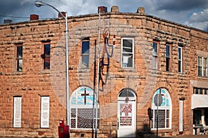 Small town middle America - Vintage downtown main street building being converted to church with Bible verses and painted crosses