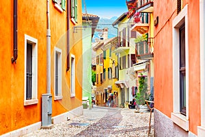 Small town narrow street view with colorful houses in Malcesine, Italy during sunny day. Beautiful lake Garda.